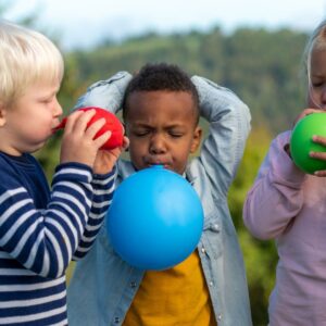 kids blowing up balloons