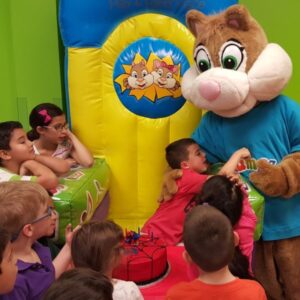 a birthday kid in the birthday throne hugging the Jumpin Jamboree mascot