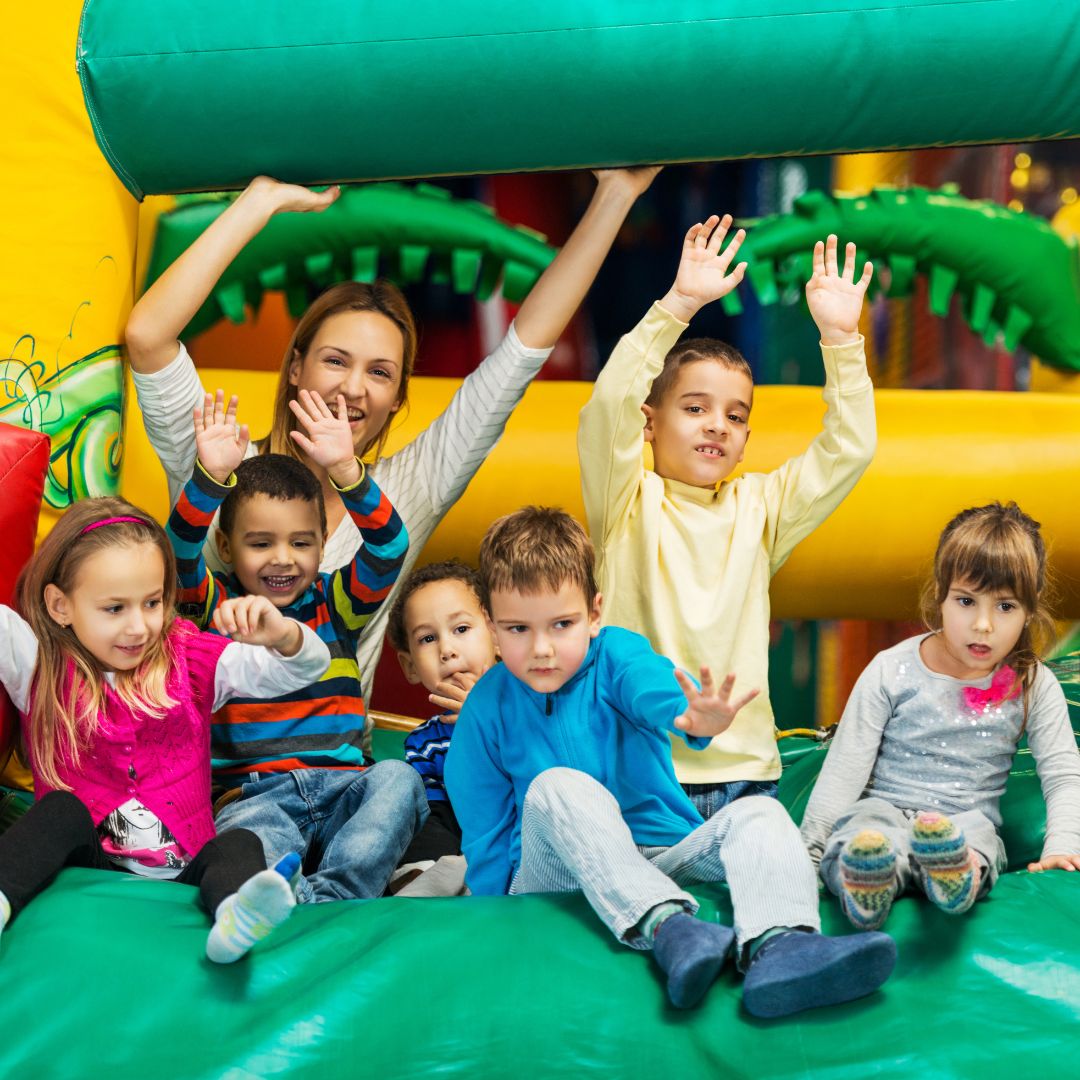 A parent and group of kids having fun at an indoor play place