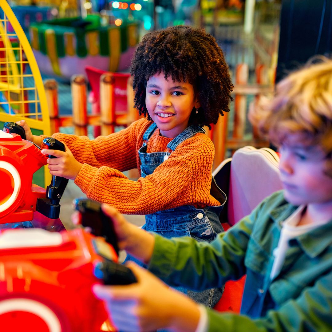 Two children playing arcade games