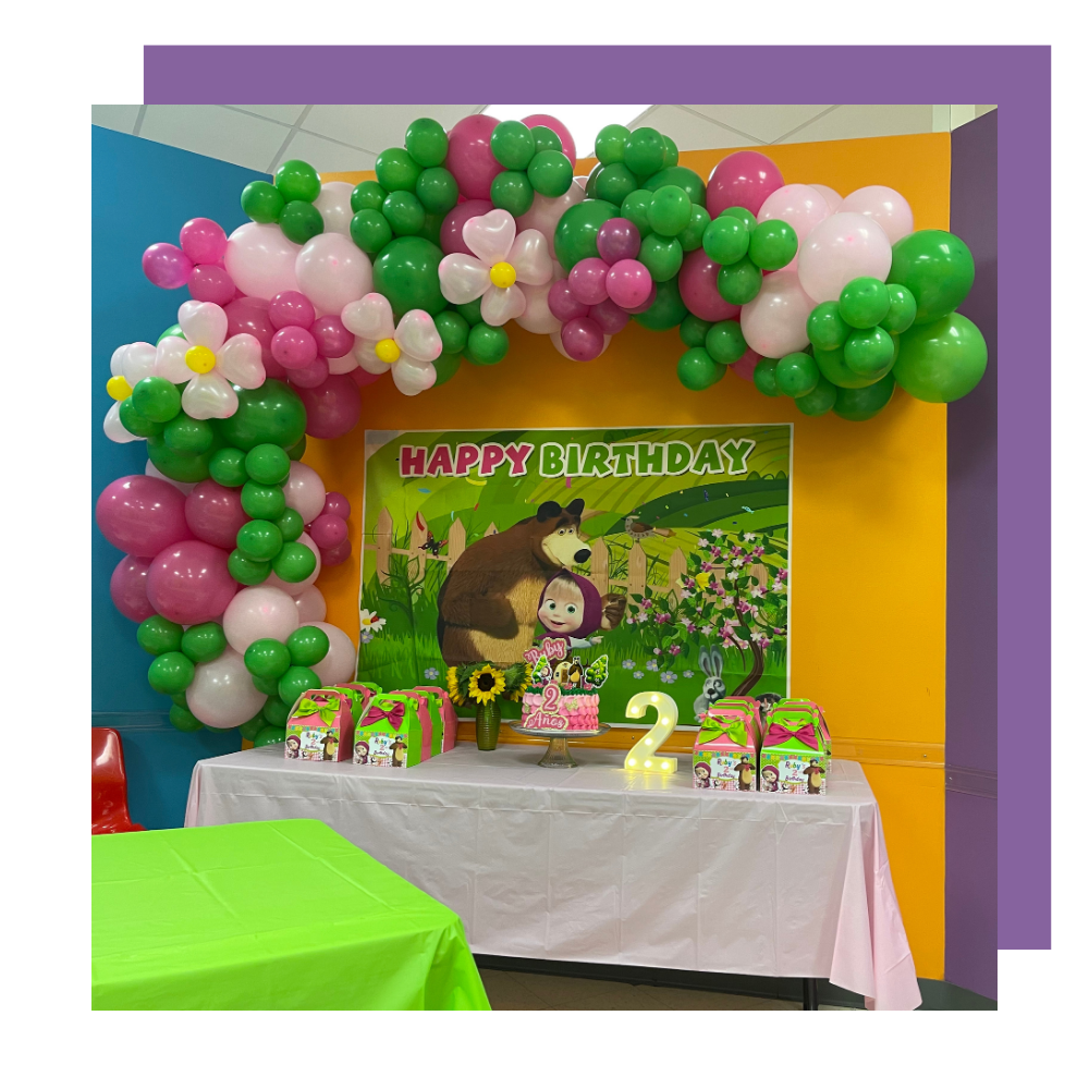 birthday table set up with balloon arch